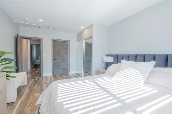 a bedroom with a large bed and a large mirror