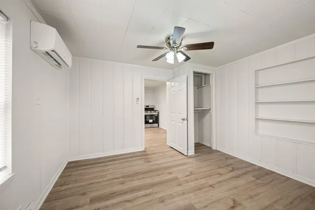 a view of empty room with wooden floor and ceiling fan