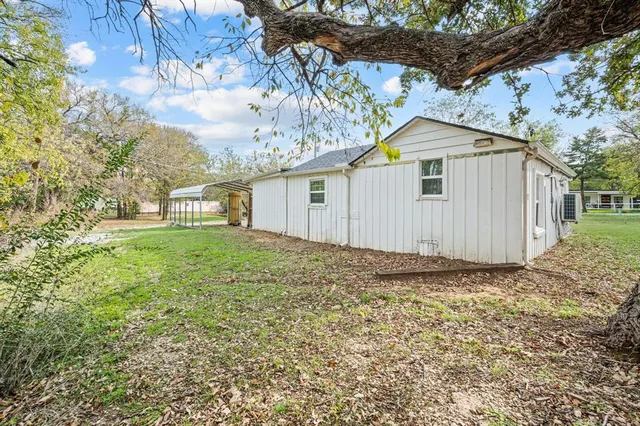 a view of a grey house with a yard