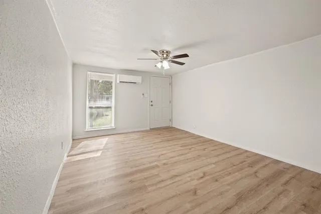 an empty room with windows and fan
