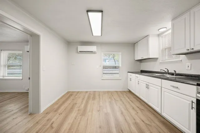 a kitchen with wooden floors and white walls
