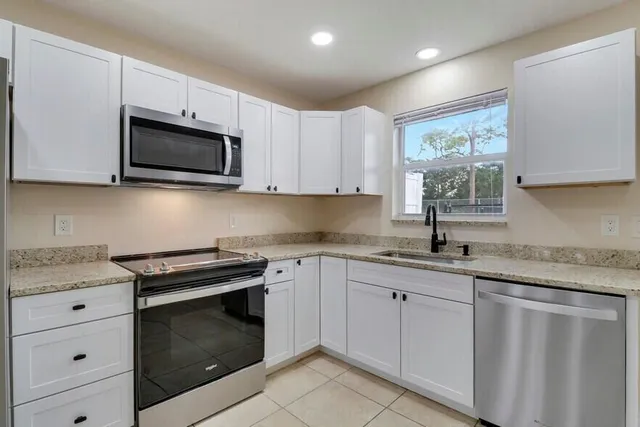 a view of a kitchen with a sink and a refrigerator