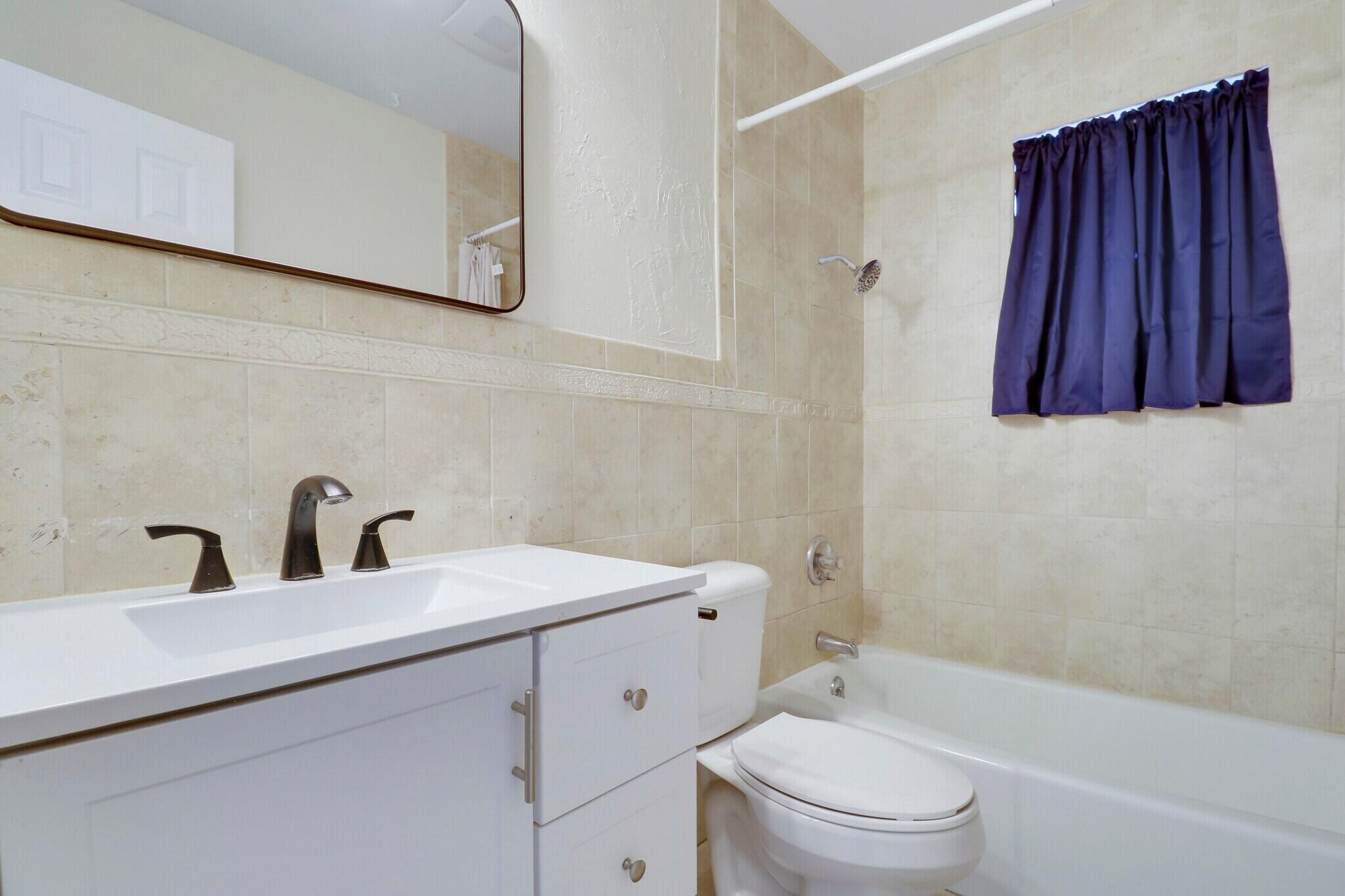2777 Southeast Normand Street Stuart, FL 34997 - Photo 10 of 14 a bathroom with a toilet a sink and bathtub