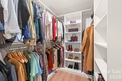 a view of walk in closet with clothes and shoes