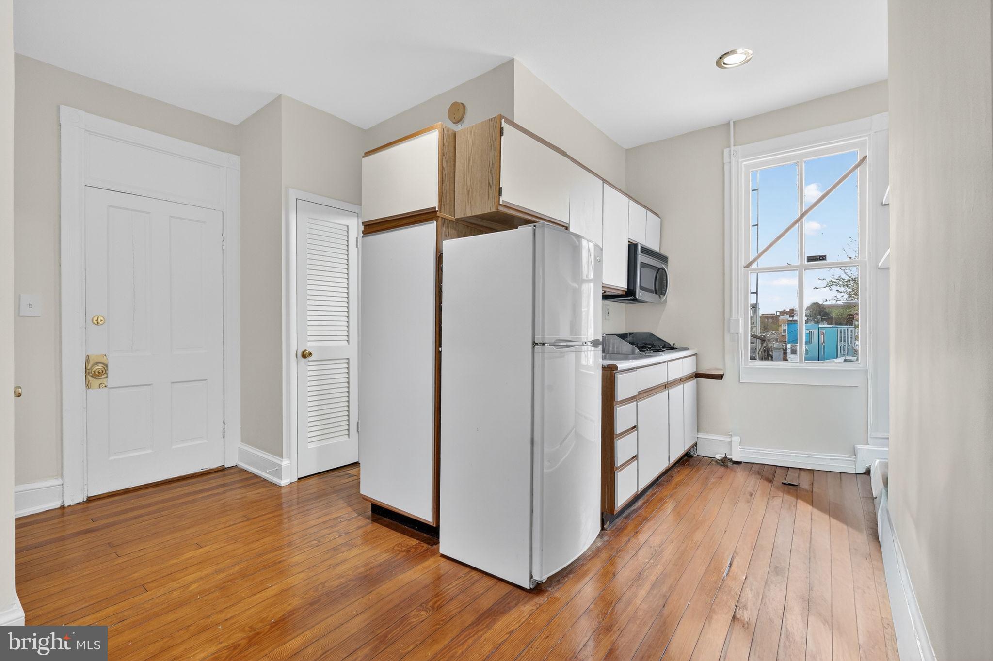 15 3rd Street Northeast, Unit 5 Washington, DC 20002 - Photo 13 of 24 a kitchen with white cabinets and wooden floor