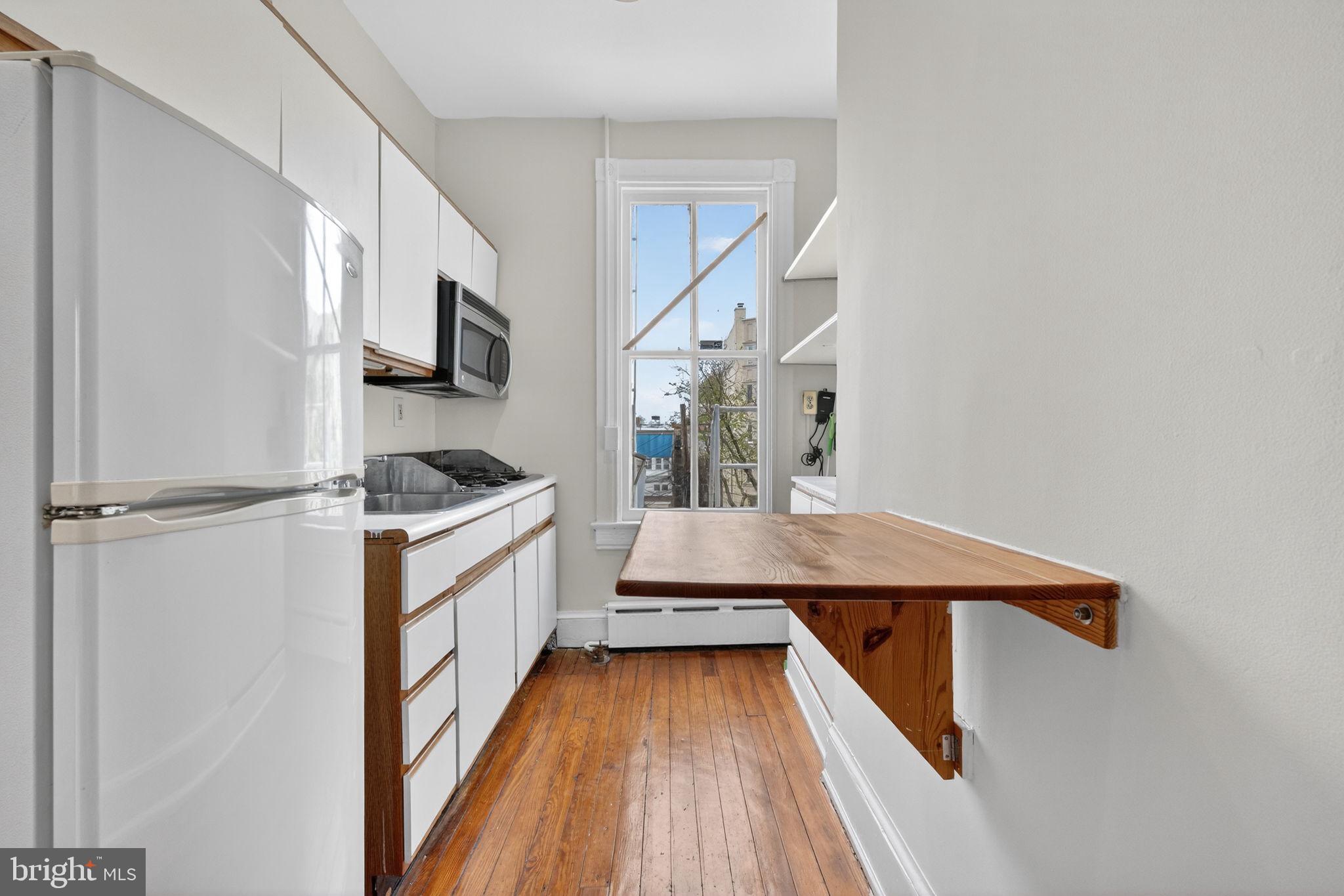 15 3rd Street Northeast, Unit 5 Washington, DC 20002 - Photo 16 of 24 a kitchen with stainless steel appliances kitchen island a white stove top oven and refrigerator