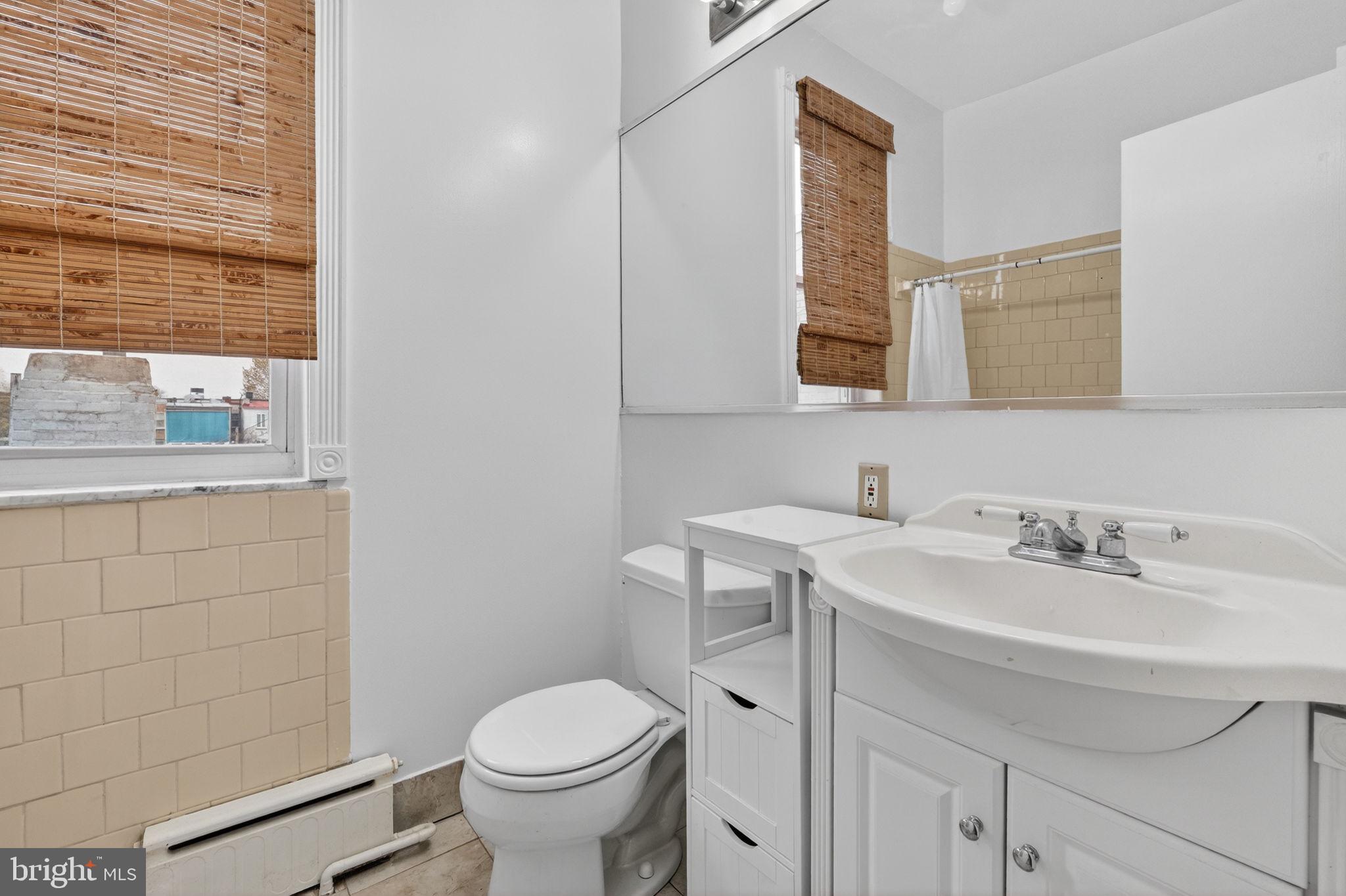 15 3rd Street Northeast, Unit 5 Washington, DC 20002 - Photo 22 of 24 a bathroom with a sink toilet and mirror