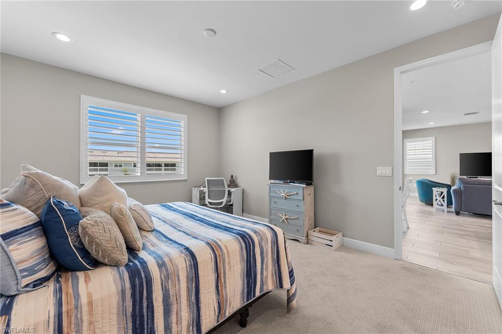 2609 Seychelles Circle, Unit 1608 Naples, FL 34112 - Photo 23 of 35 a bedroom with a bed and a television in it