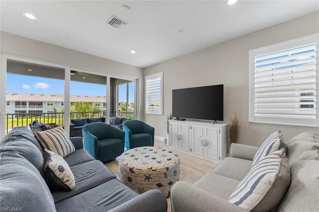 a living room with furniture large window and a flat screen tv