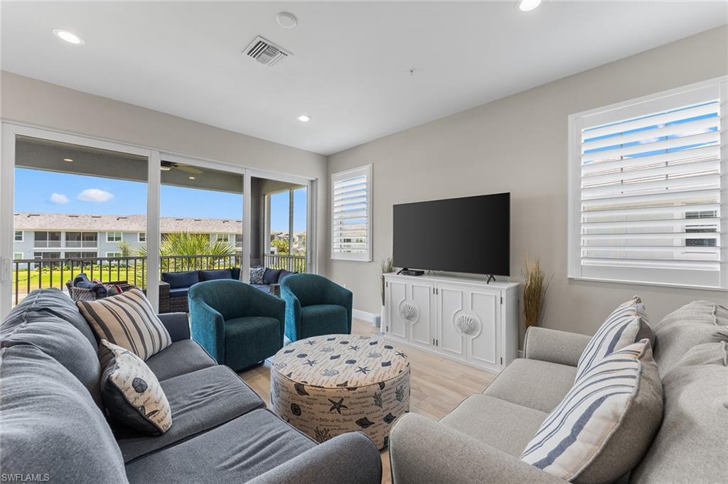 2609 Seychelles Circle, Unit 1608 Naples, FL 34112 - Photo 5 of 35 a living room with furniture large window and a flat screen tv