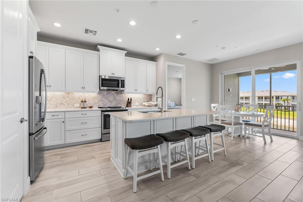 2609 Seychelles Circle, Unit 1608 Naples, FL 34112 - Photo 10 of 35 a kitchen with appliances cabinets and chair