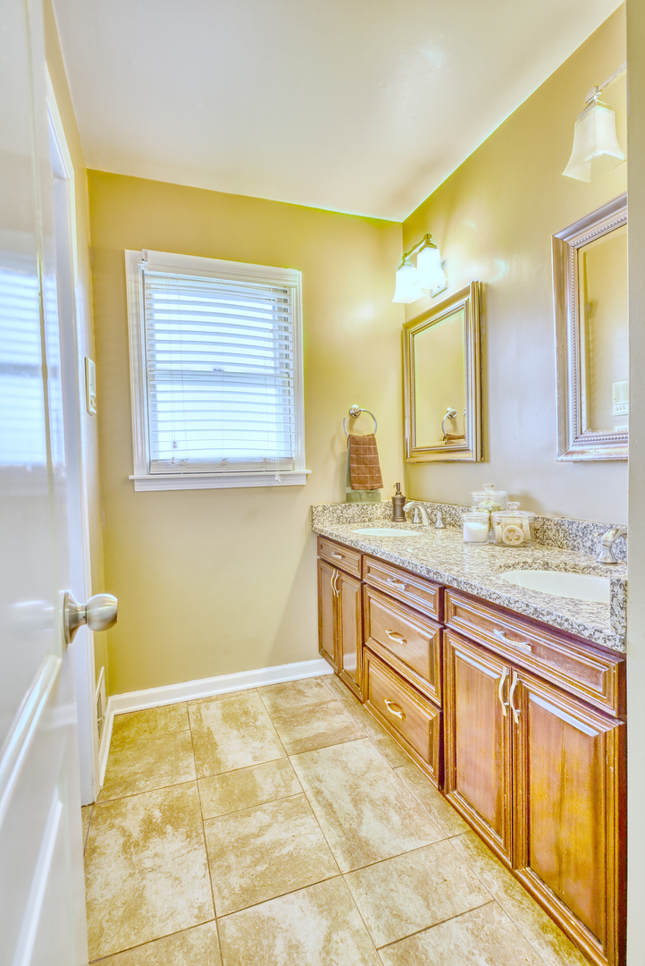 1121 Old Fence Road Addison, IL 60101 - Photo 25 of 33 a bathroom with a granite countertop sink and a bathtub