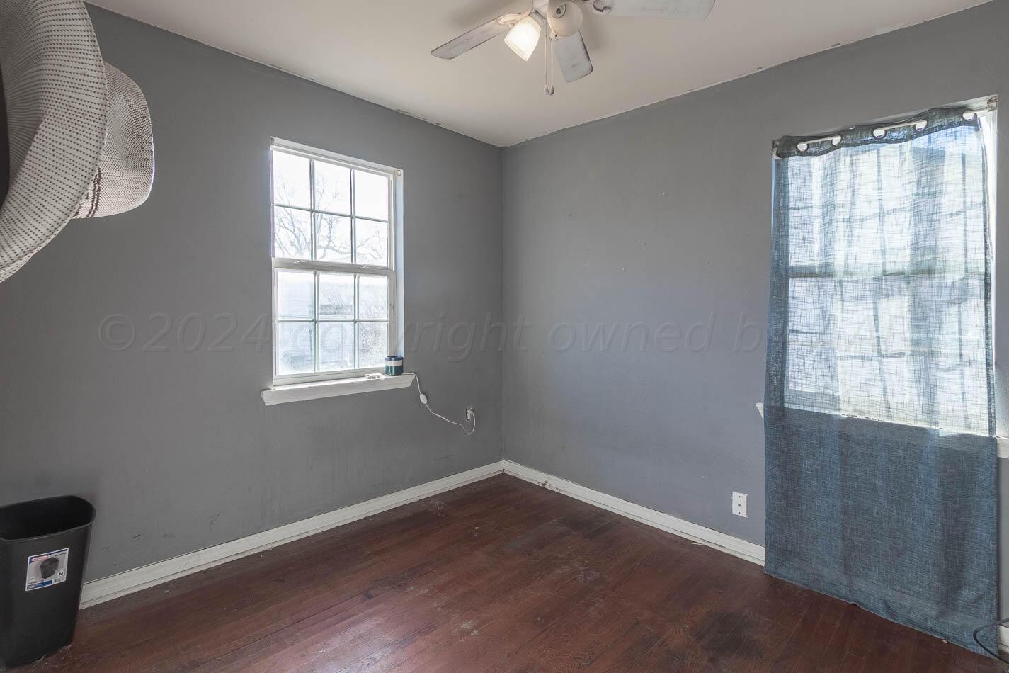 4101 South Washington Street Amarillo, TX 79110 - Photo 8 of 12 an empty room with wooden floor and windows