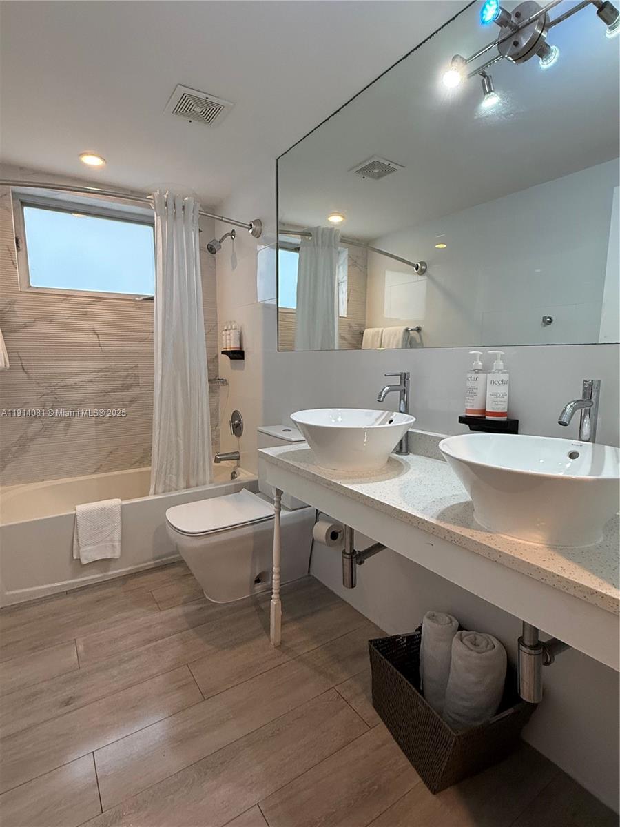 6755 Harding Avenue, Unit 3 Miami Beach, FL 33141 - Photo 4 of 7 a bathroom with a sink double vanity and a bathtub