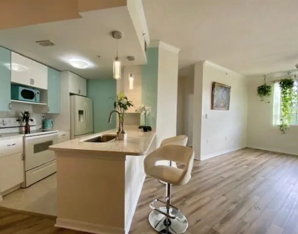 a kitchen with kitchen island stainless steel appliances a sink dining table and chairs