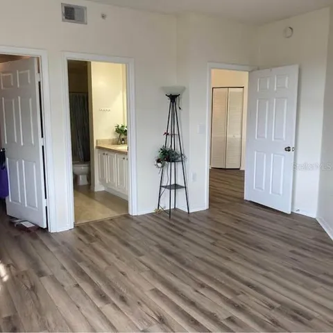 a view of empty room with wooden floor and stairs