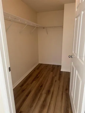 a view of a room with wooden floor and white walls
