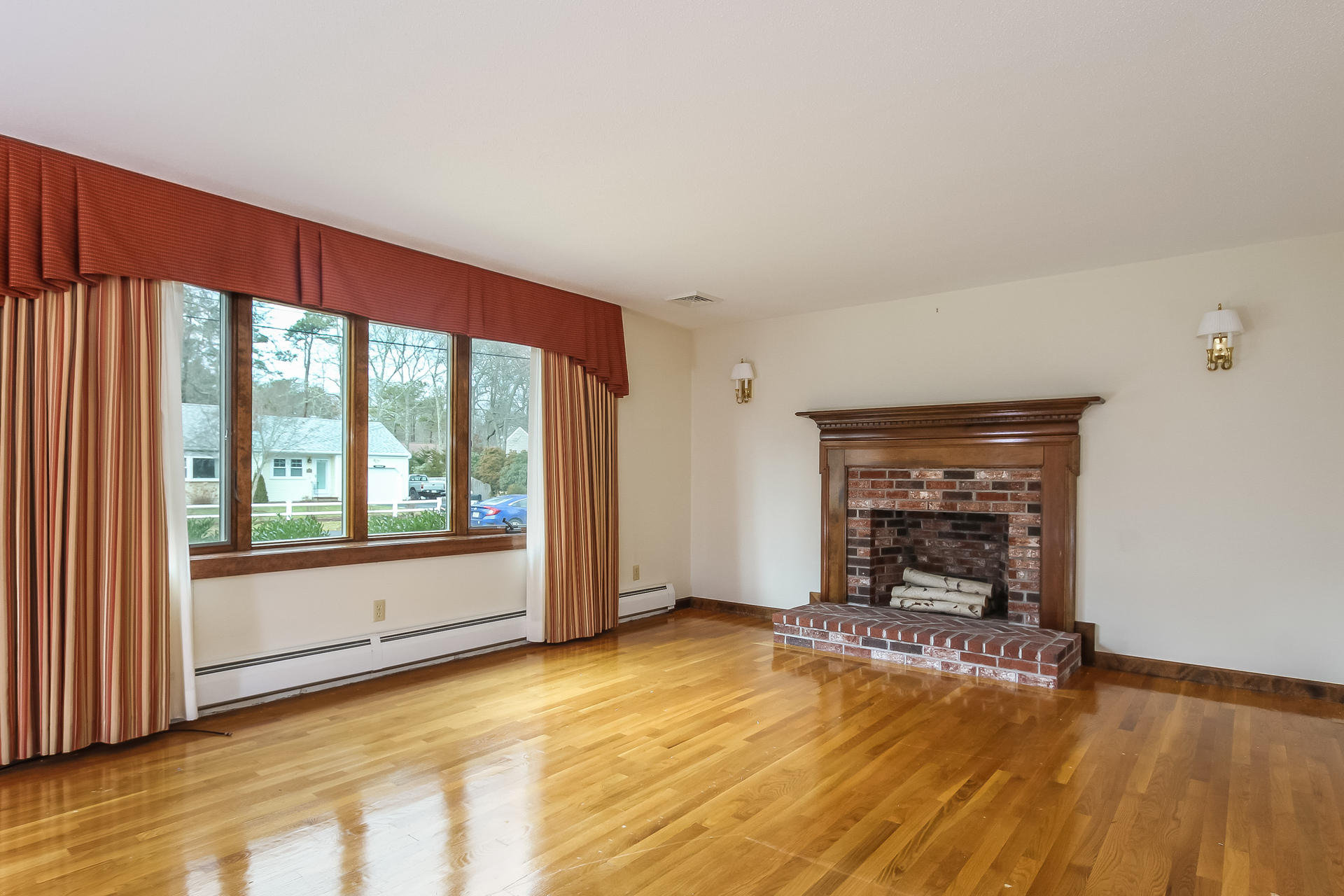 173 Rolling Hitch Road Centerville, MA 02632 - Photo 5 of 22 a view of empty room with wooden floor and fireplace