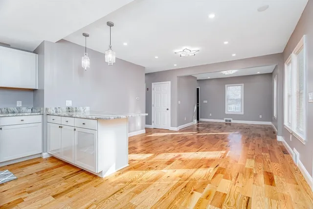 a view of large kitchen with granite countertop a stove a sink dishwasher and a refrigerator with wooden floor