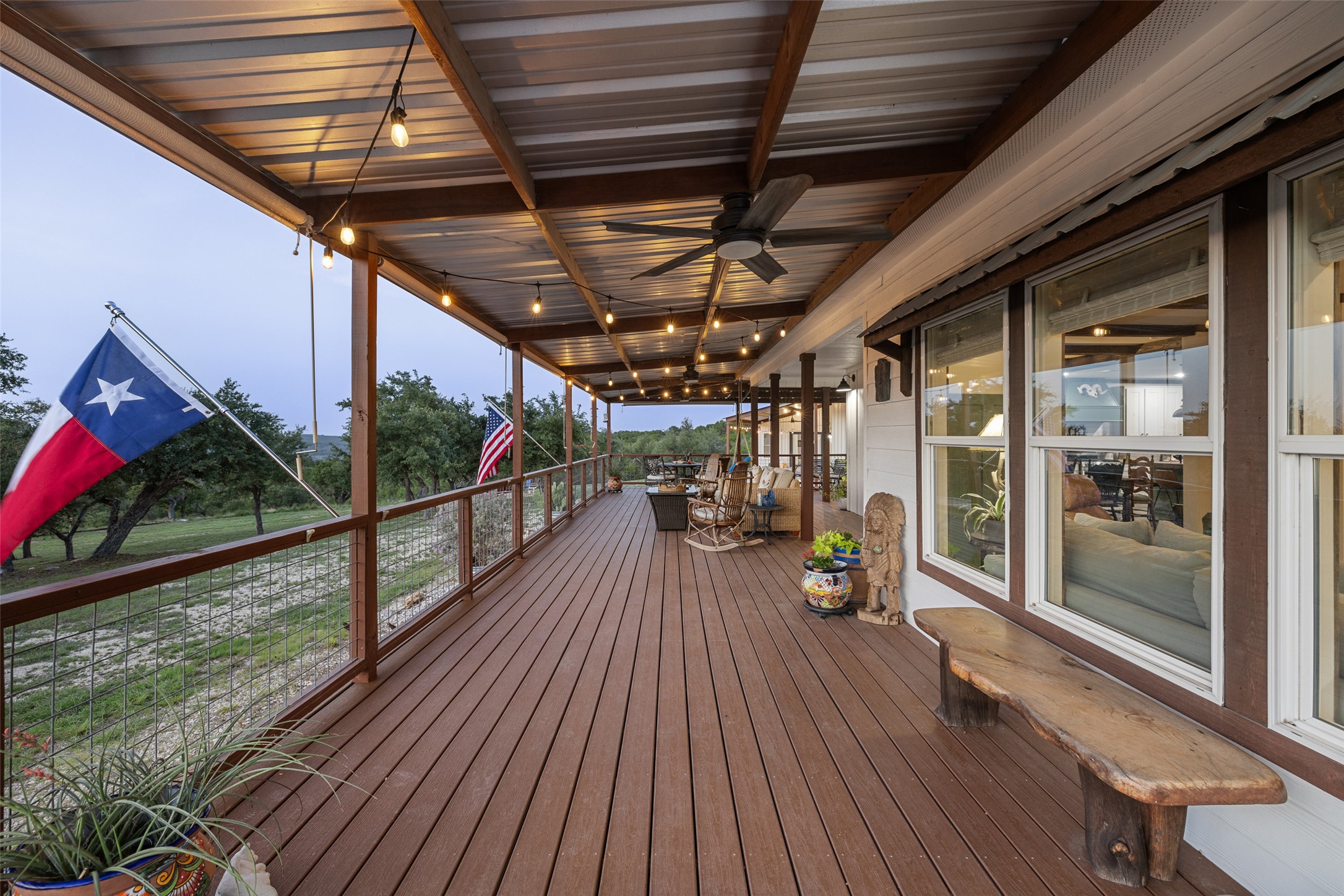 830 Ulrich Road Johnson City, TX 78636 - Photo 16 of 40 A deep, inviting deck with a ceiling fan and string lighting offers expansive outdoor living space.