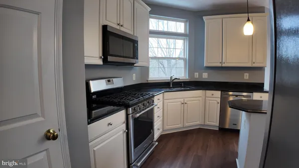 a kitchen with granite countertop cabinets stainless steel appliances and a window