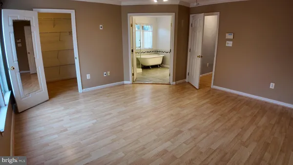 an empty room with wooden floor and a bathroom