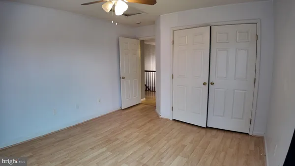 a view of a room with wooden floor and a ceiling fan