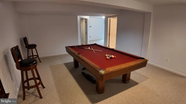 a room with pool table and windows