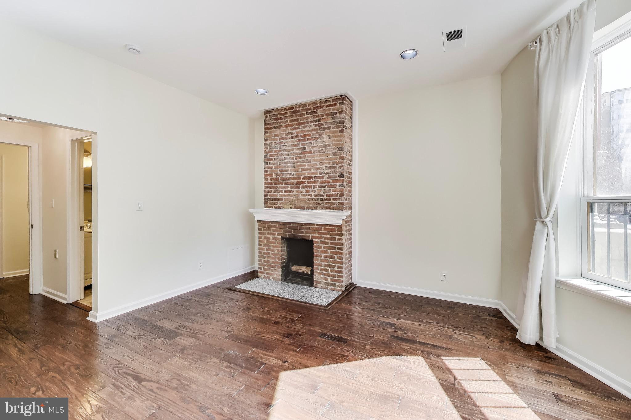 1625 S Street Northwest, Unit 1 Washington, DC 20009 - Photo 8 of 13 a view of an empty room with wooden floor and a window