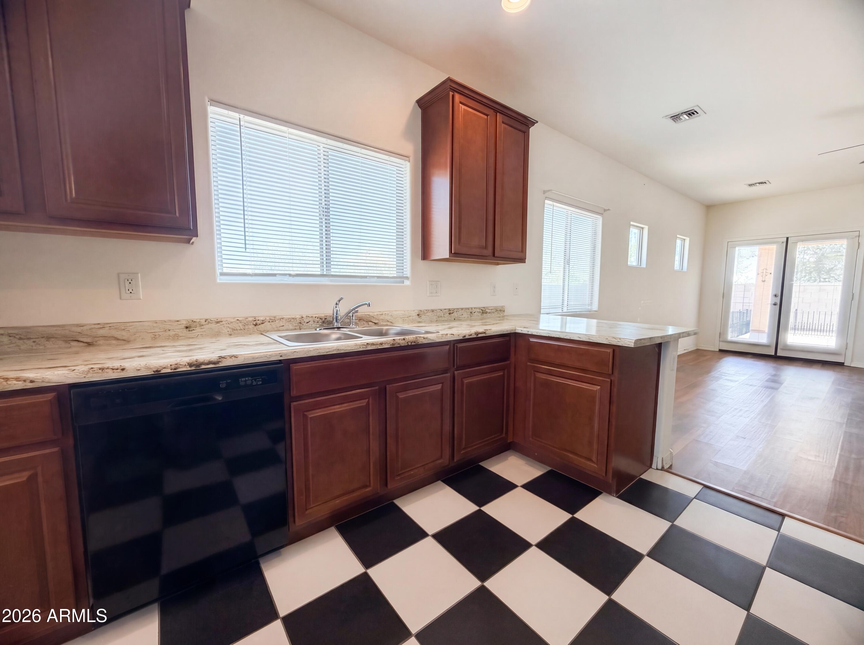 1738 South Aryelle Road Apache Junction, AZ 85119 - Photo 10 of 17 a kitchen with a black white checkered floor and a sink