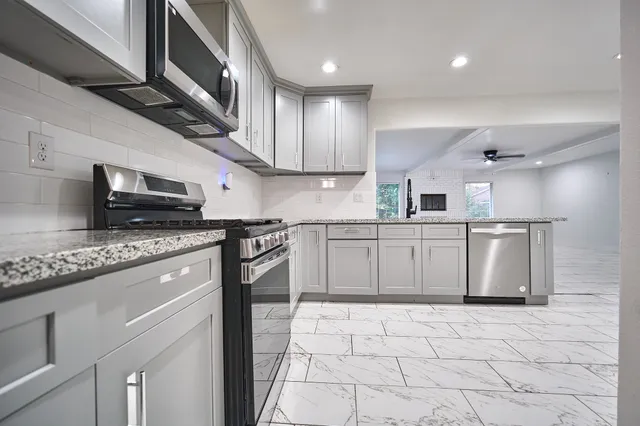 a kitchen with stainless steel appliances granite countertop a sink stove and refrigerator