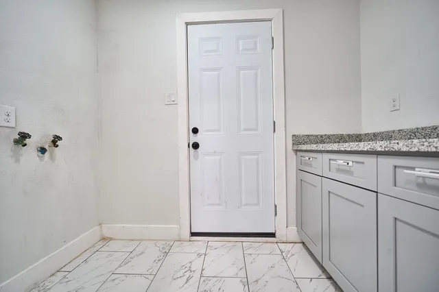 a view of a kitchen with white cabinets
