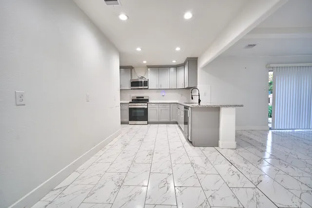a kitchen with stainless steel appliances cabinets a sink and a stove top oven