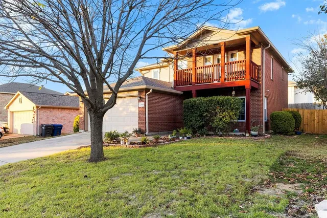 a front view of a house with a yard and trees