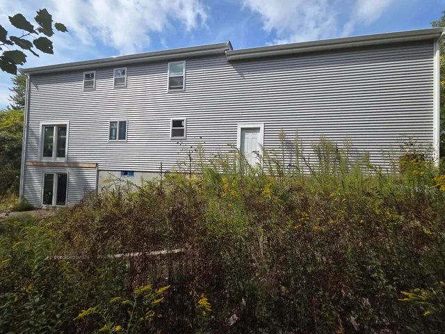 a front view of a house with plants