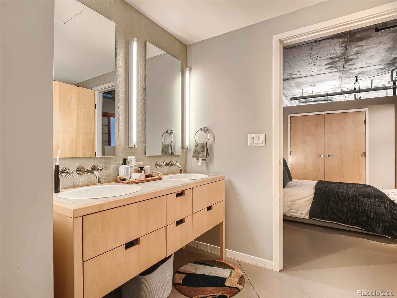 2100 16th St Mall, Unit 604 Denver, CO 80202 - Photo 14 of 20 a en suite bathroom with a double vanity sink and a mirror