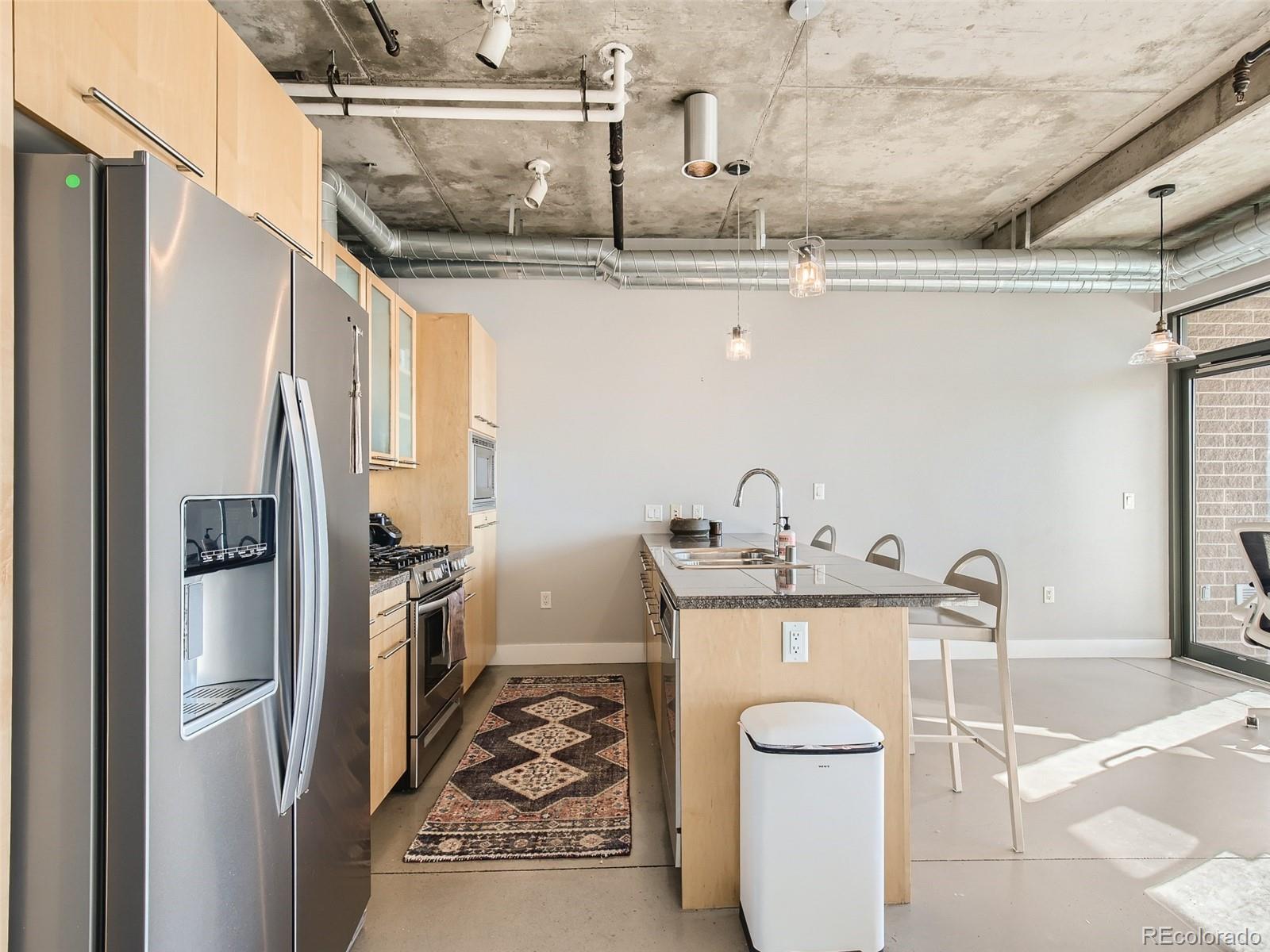 2100 16th St Mall, Unit 604 Denver, CO 80202 - Photo 7 of 20 a kitchen with a sink a stove and refrigerator