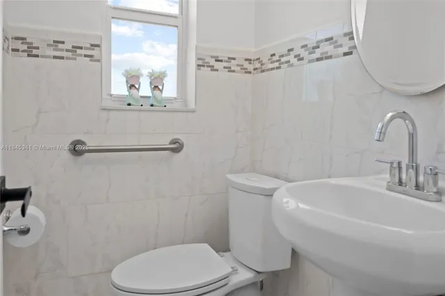a white toilet sitting next to a bathroom sink