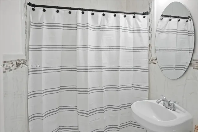 a bathroom with a sink a mirror and shower