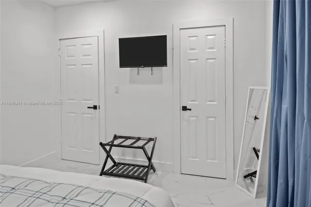 a bedroom with a bed and a flat screen tv