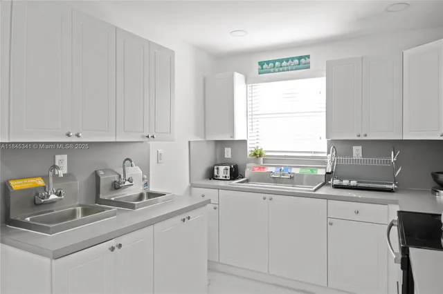 a kitchen with cabinets appliances a sink and a window