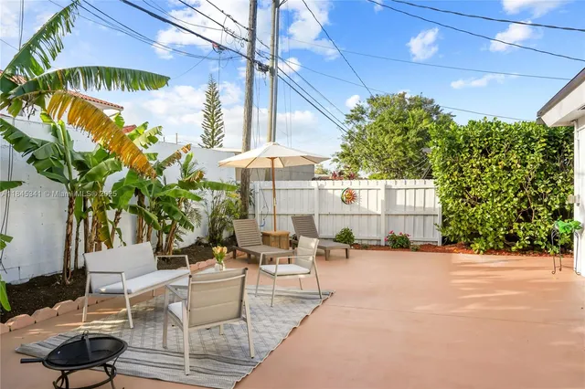 a view of a backyard with furniture and garden