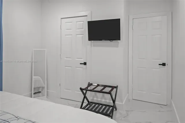 a bedroom with a bed and a flat screen tv