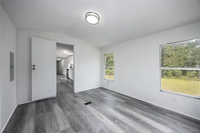 an empty room with windows and closet