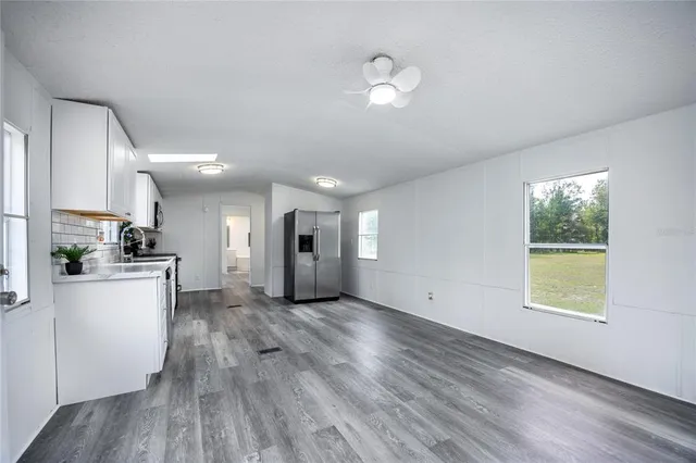 a view of empty room with wooden floor and window