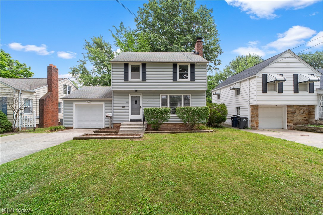 View of front of home featuring a garage and a front yard