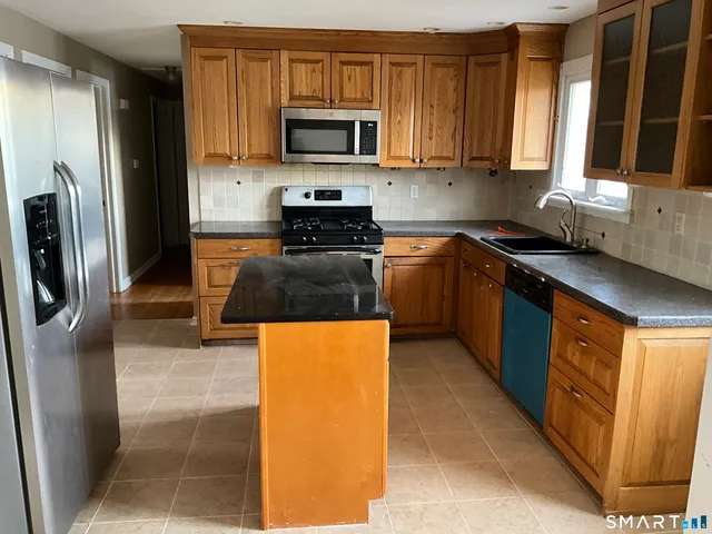 a kitchen with stainless steel appliances granite countertop a refrigerator a stove top oven a sink and dishwasher