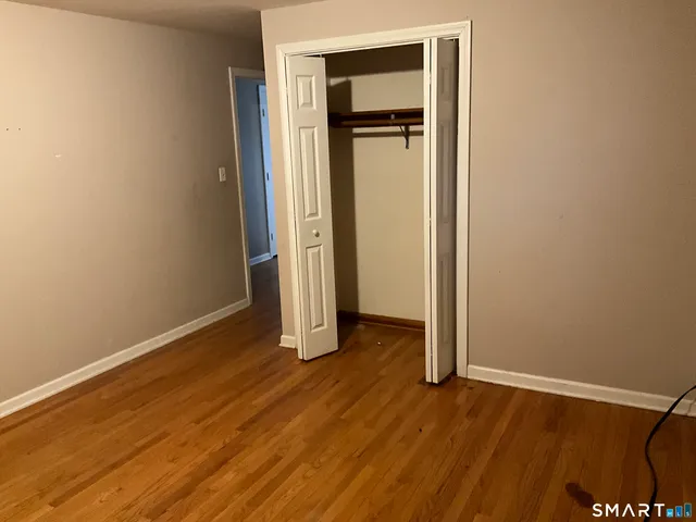 an empty room with wooden floor and closet