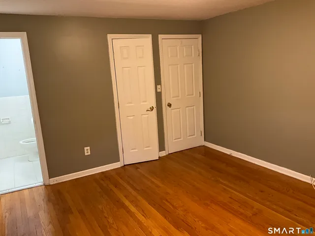 an empty room with wooden floor and closet
