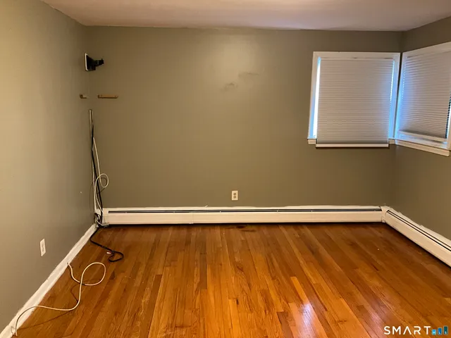 a view of a room with wooden floor and a window